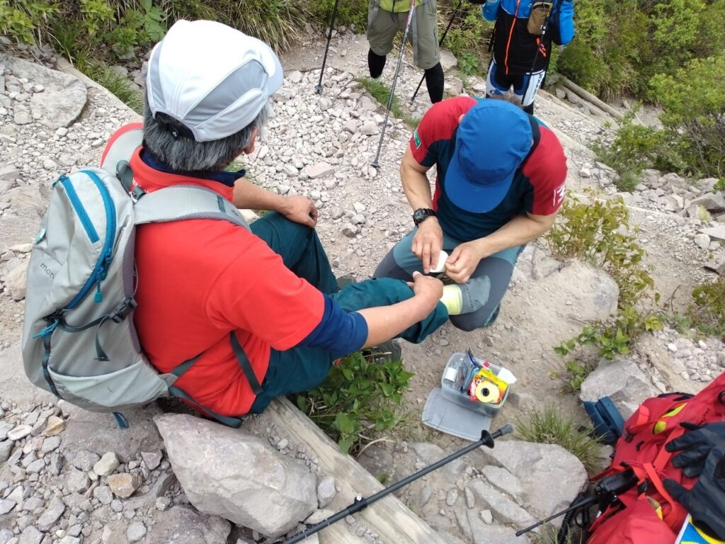 登山者へファーストエイドをしている